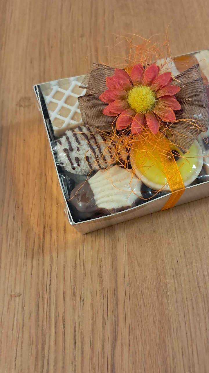 Originalfoto: Geschenkbox mit gemischten Guetzli, mit dem Handy auf dem Holztisch fotografiert